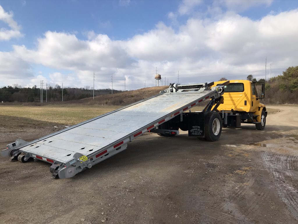 A QuickLoadz 20k Super Bed with the bed fully extended and lowered to the ground, ready to load.