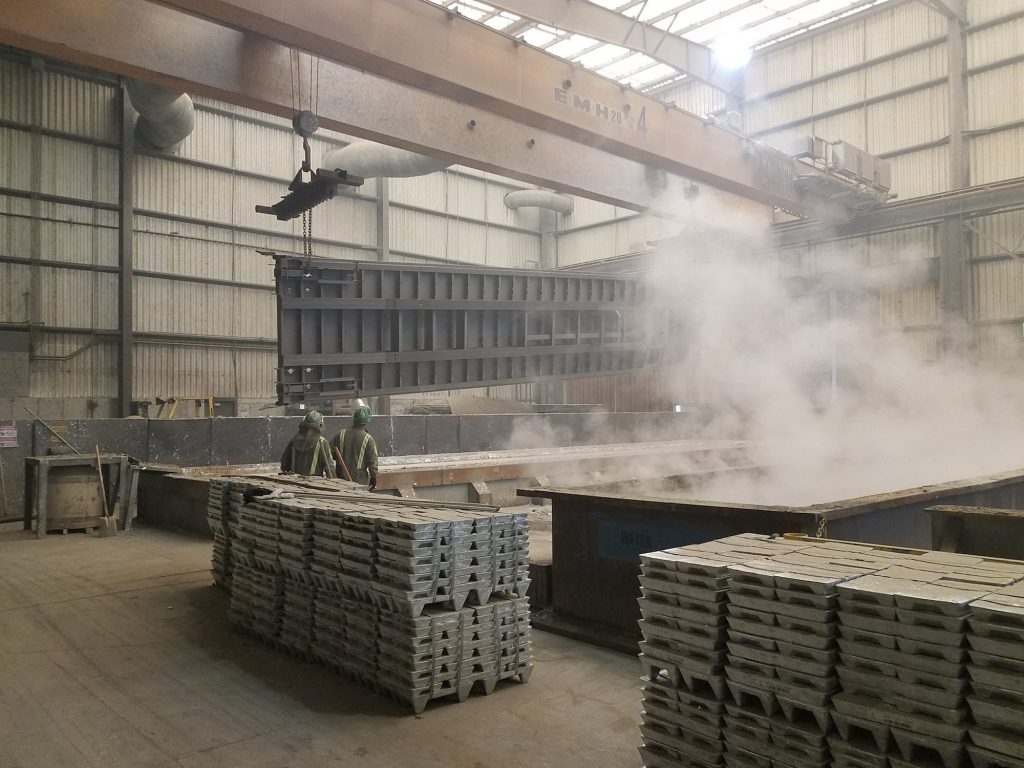 A trailer being lowered by crane into a vat to be hot dip galvanized at the QuickLoadz headquarters.