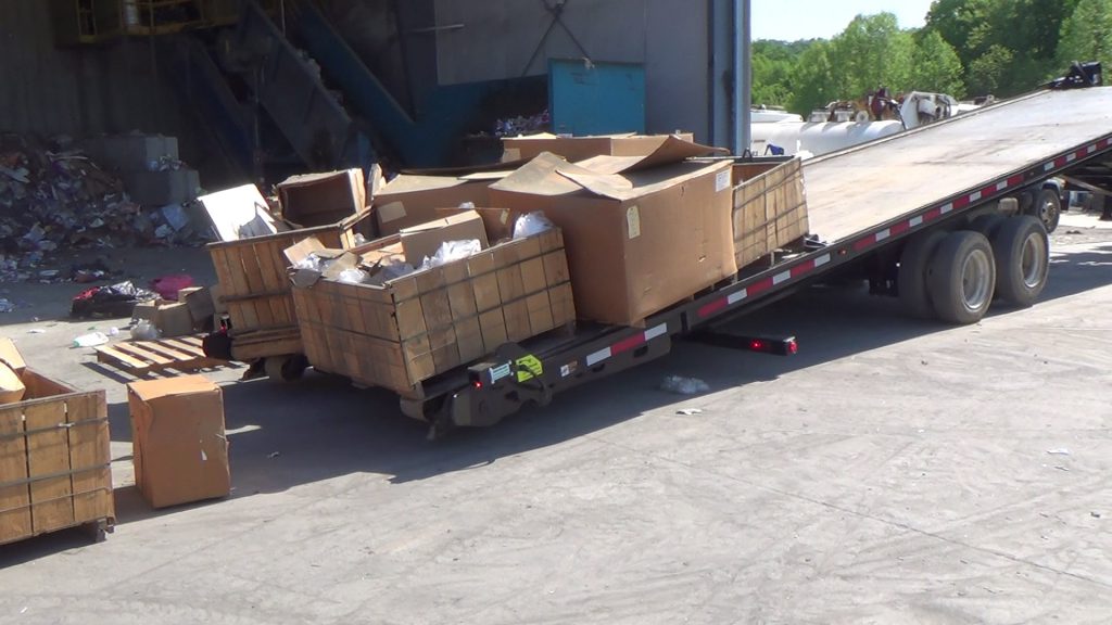 A QuickLoadz trailer is unloading pallets with the tow bar.