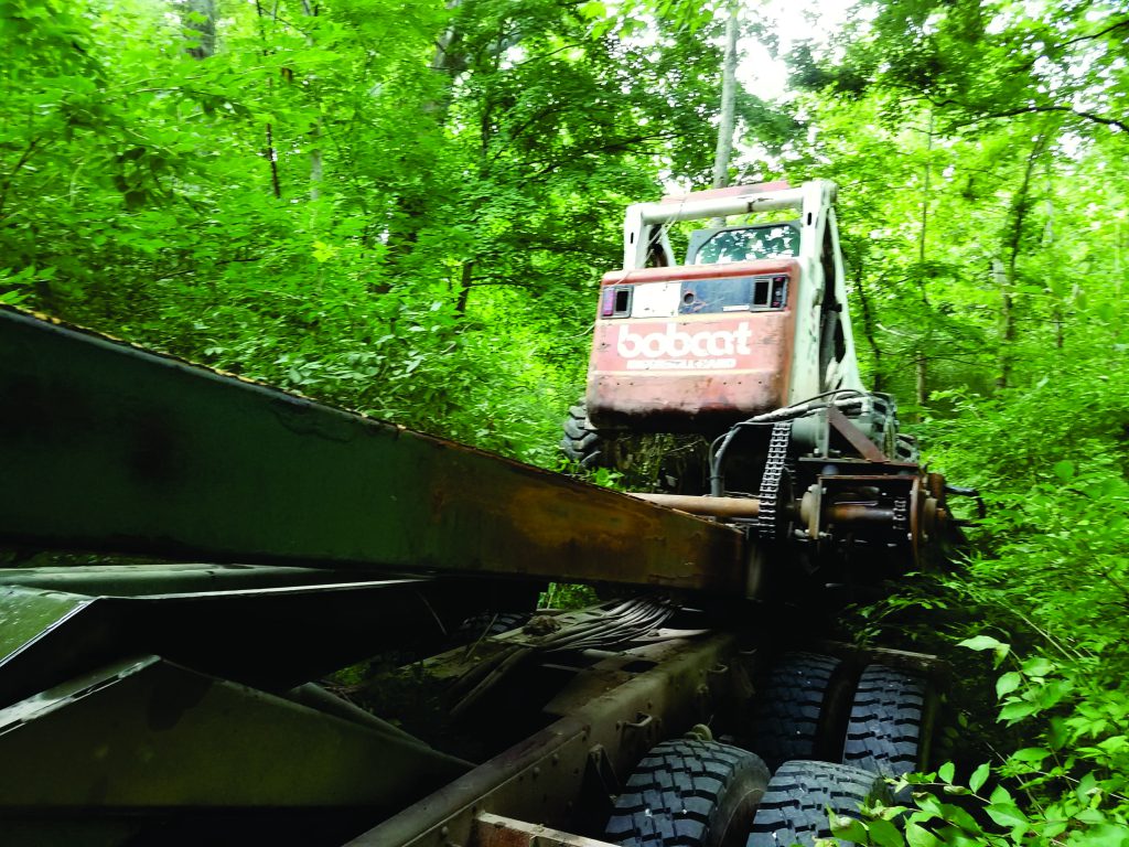 Skid steer drives off the bed.